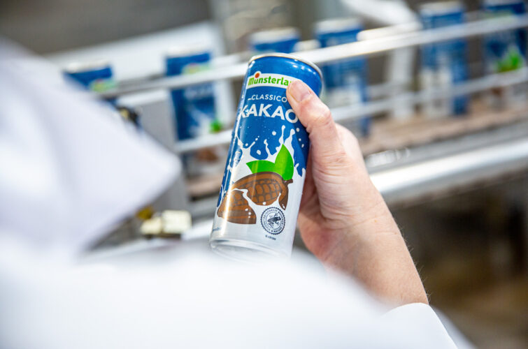 Kakaomilchdose in Hand in Produktionshalle