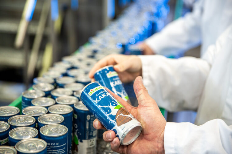 Kakaomilchdose in Hand in Produktionshalle